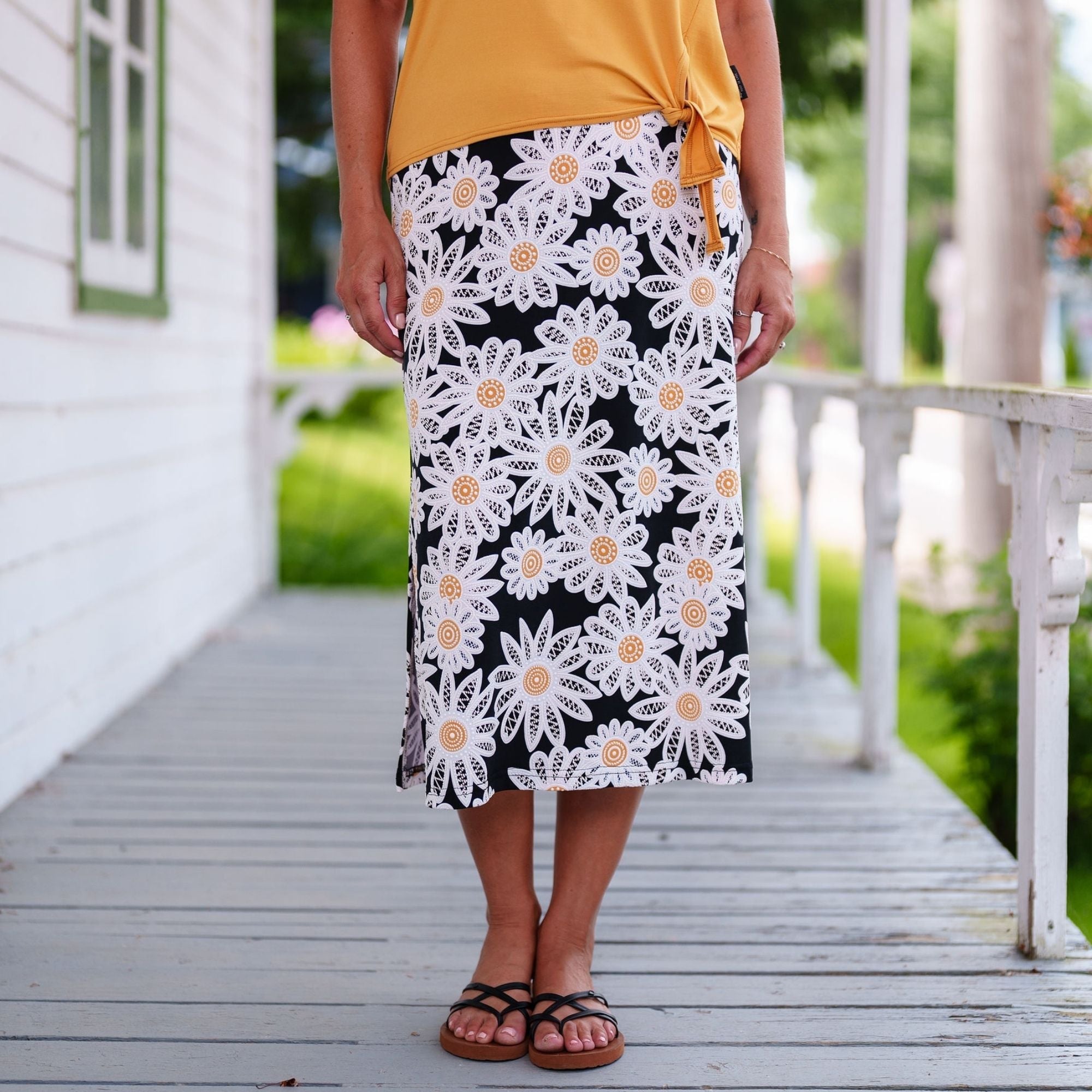 Jupe mi-longue Fiesta avec bande élastique à la taille, tissu extensible et infroissable, ouvertures sur les côtés et style féminin polyvalent.