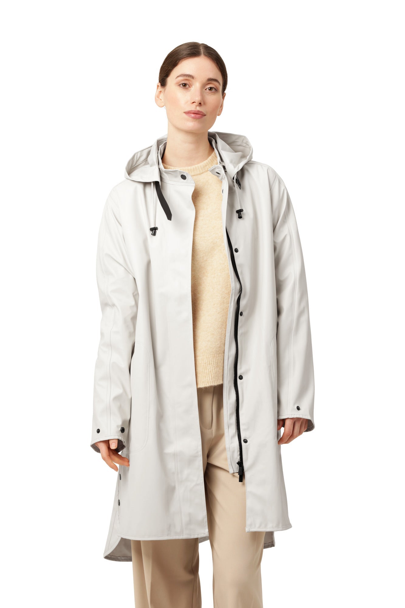 Imperméable long de couleur crème avec capuchon amovible, coupe droite, extérieur en polyuréthane et doublure intérieure en polyester, style élégant et fonctionnel.