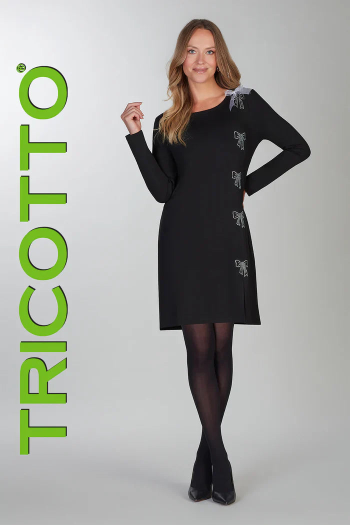 Robe noire à manches longues de la compagnie Tricotto avec une boucle en tulle blanche et des boucles en paillettes scintillantes. Elle a un col rond, une petite fente à l'avant et est faite d'un tissu de grande qualité très extensible.