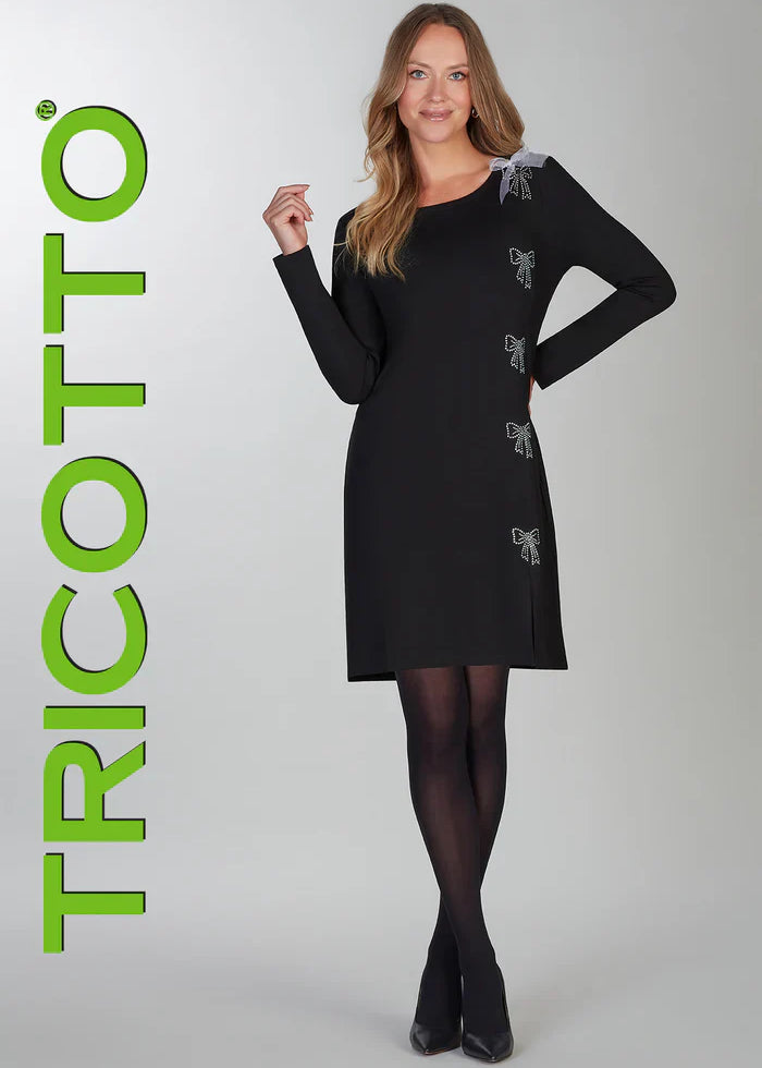 Robe noire à manches longues de la compagnie Tricotto avec une boucle en tulle blanche et des boucles en paillettes scintillantes. Elle a un col rond, une petite fente à l'avant et est faite d'un tissu de grande qualité très extensible.