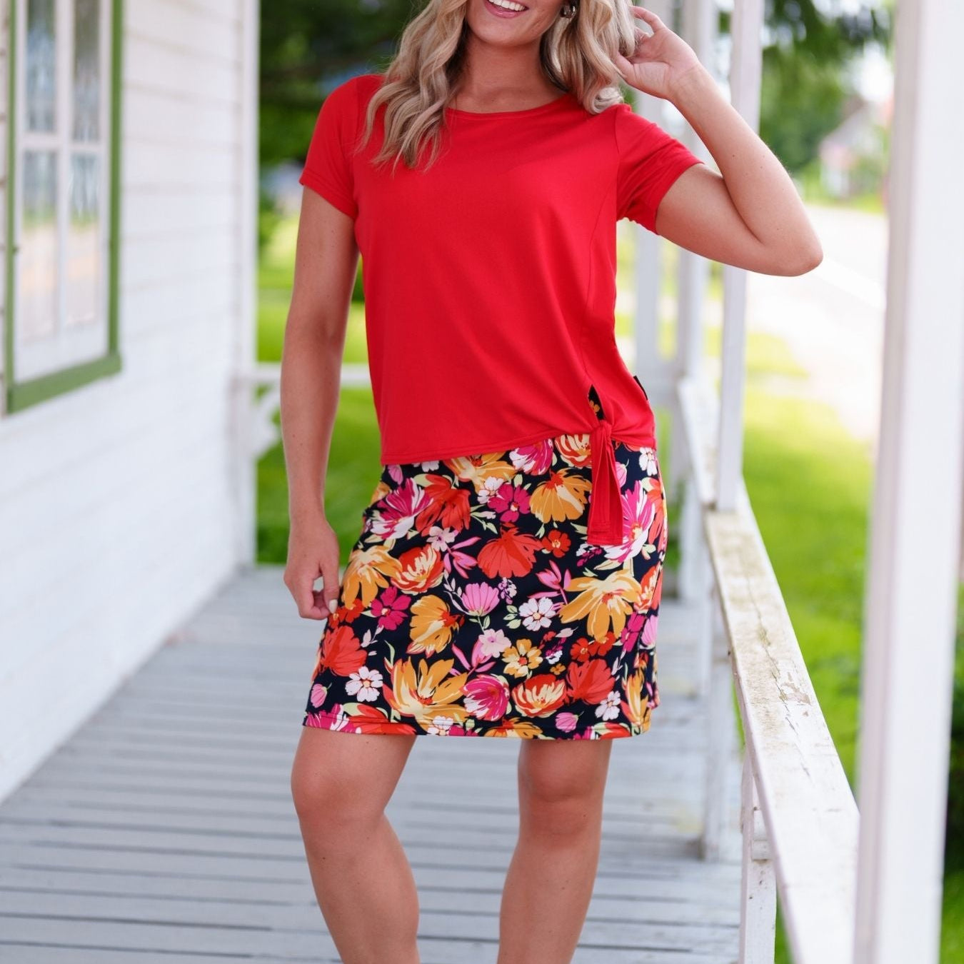 Jupe-cuissard Rien ne se perd avec imprimé de fleurs roses et orangées sur fond noir, en tissu extensible 95% polyester et 5% élasthanne.