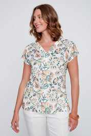 T-shirt pour femme de couleur crème avec imprimé aux touches de vert et d’orangé, tissu souple et confortable.