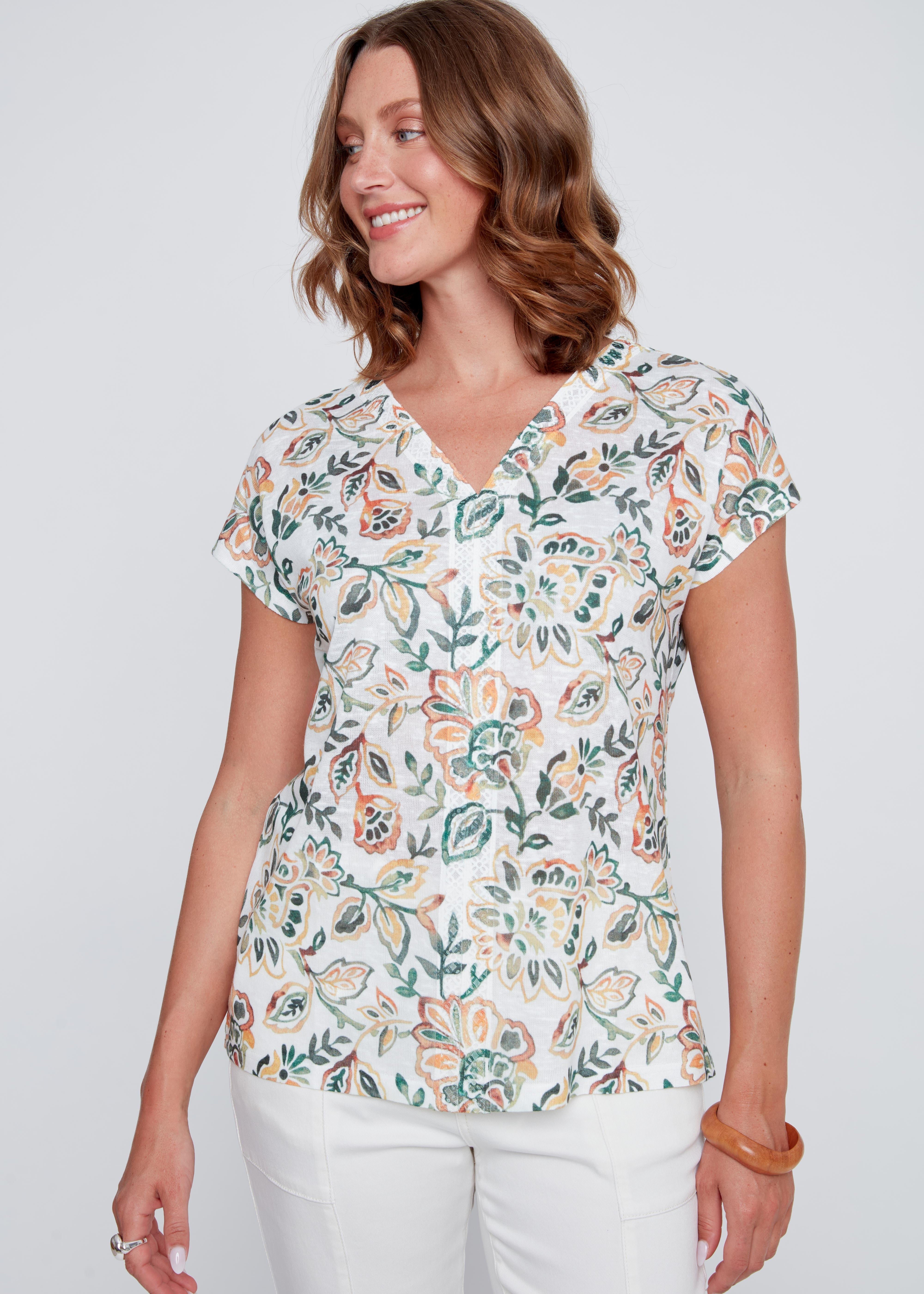 T-shirt pour femme de couleur crème avec imprimé aux touches de vert et d’orangé, tissu souple et confortable.