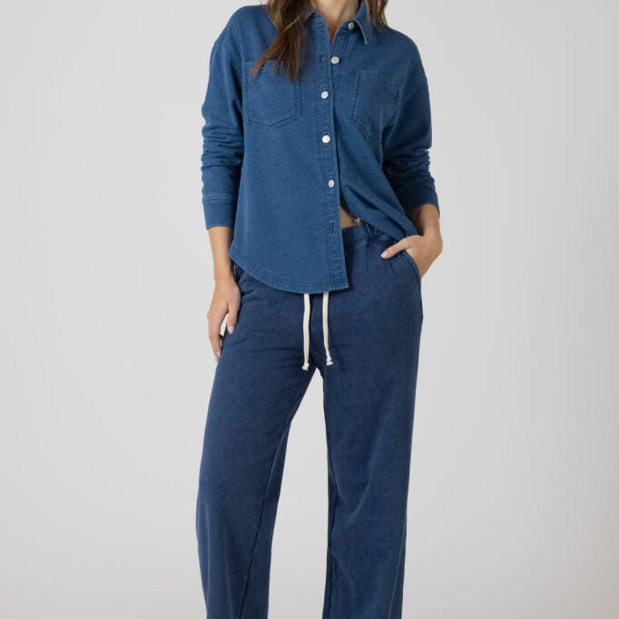 Jogging pour femme effet jeans foncé presque marine, jambe large, taille élastique avec cordon ivoire, deux poches, style décontracté et chic pour détente ou sorties confortables.
