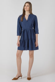 Robe courte pour femme style paysanne, col V, manches trois quarts, ceinture amovible à la taille, tissu en tencel bleu denim effet légèrement délavé, allure estivale et confortable.