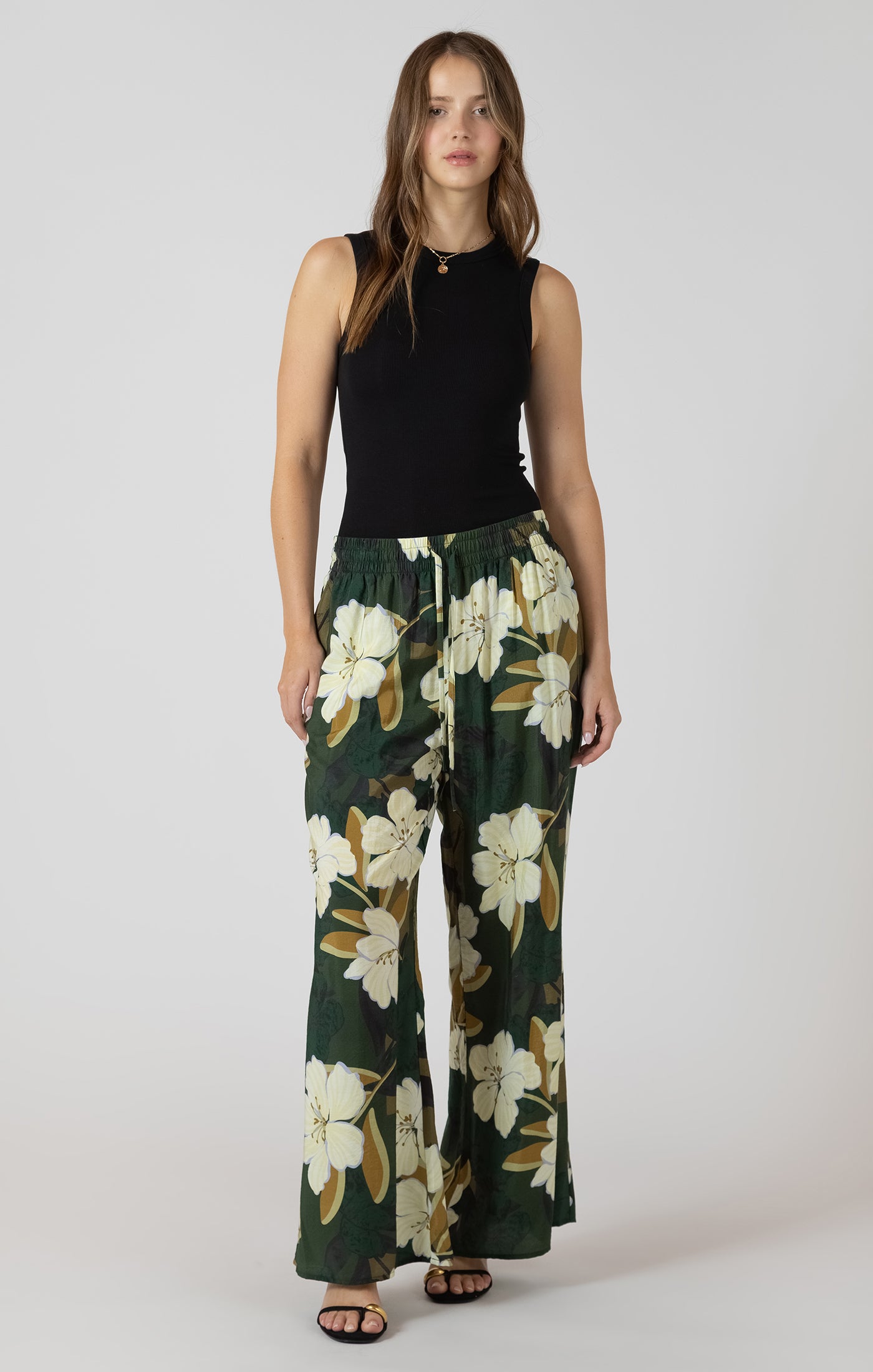 Pantalon large vert forêt avec imprimé de fleurs et taille élastique, style fluide, féminin et confortable.
