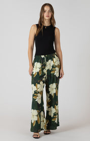 Pantalon large vert forêt avec imprimé de fleurs et taille élastique, style fluide, féminin et confortable.