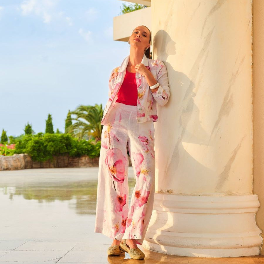 Pantalon pour femme en lin blanc avec imprimé floral artistique, tissu léger et respirant avec finitions soignées.