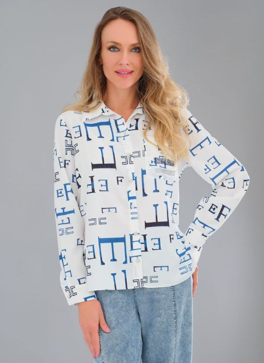 Blouse blanche fluide infroissable avec imprimé de lettres bleues, bouton nacré en forme de fleur et détails de strass sur la poche avant.